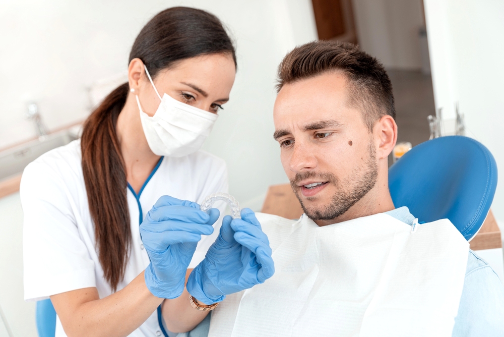 dentist shows invisalign clear aligners after explaining about invisalign cost in little rock, ar
