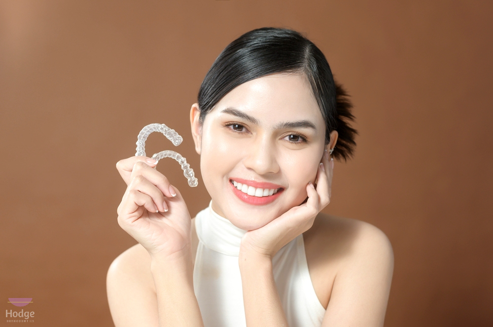 young woman beautiful teeth holding invisalign clear aligners healthy dental concept - How Long Does Invisalign Take in Little Rock, AR 